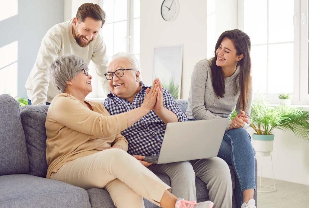 Happy family, aging old parents and adult children, two generations learn using laptop online home. Senior people, grown kids in loving kind affection, trust, family care, peace over generations