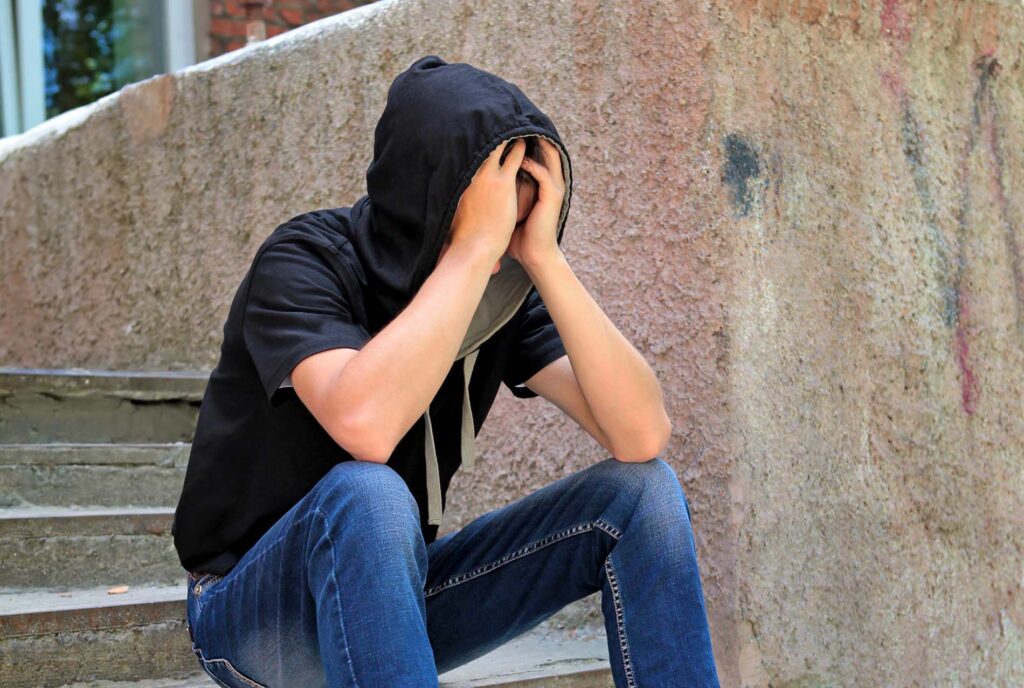 Sad Teenager on the landing steps of the Old House